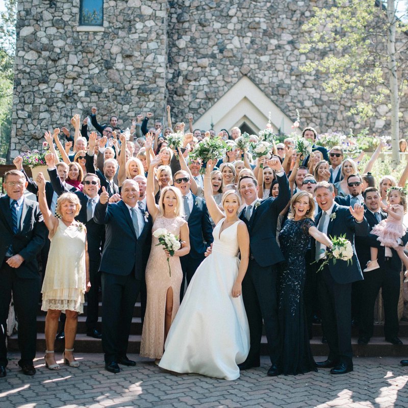 beaver creek chapel group photo on steps after wedding ceremony, bride and groom surrounded by wedding guests cheering, mountain wedding inspiration, colorado wedding planning