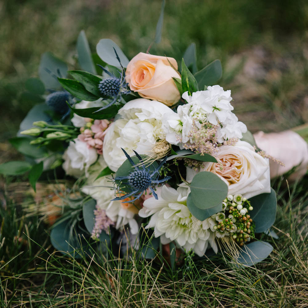 Bridal bouquet laying in grass, detail photos, wedding day, denver wedding planner, sweetly paired weddings, summer wedding inspiration, spruce mountain ranch wedding planner