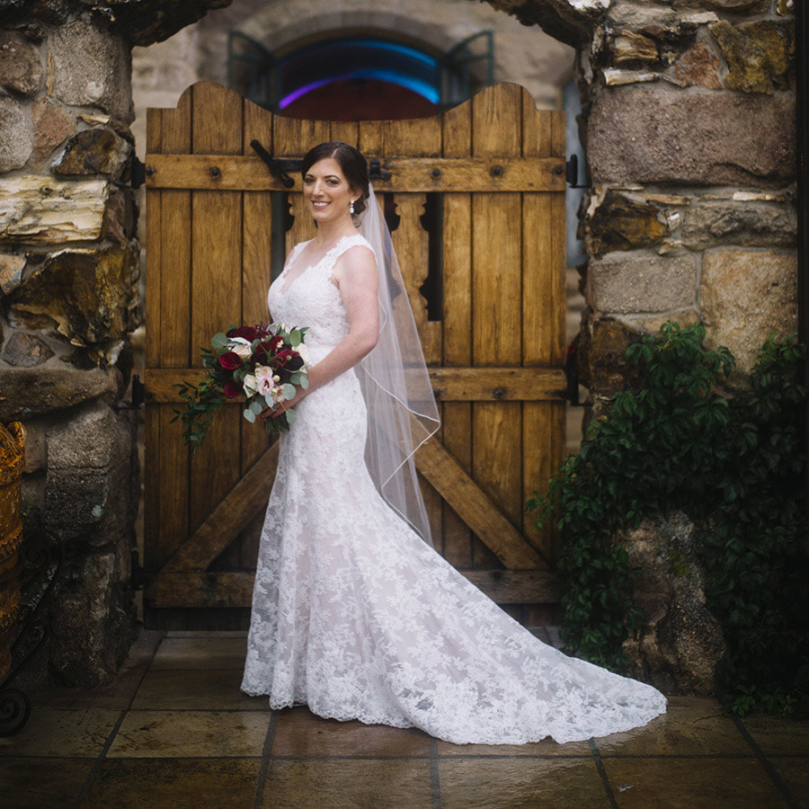 bridal portrait in front of wooden doors at historic cherokee ranch and castle, colorado wedding inspiration, mountain wedding planning, sweetly paired