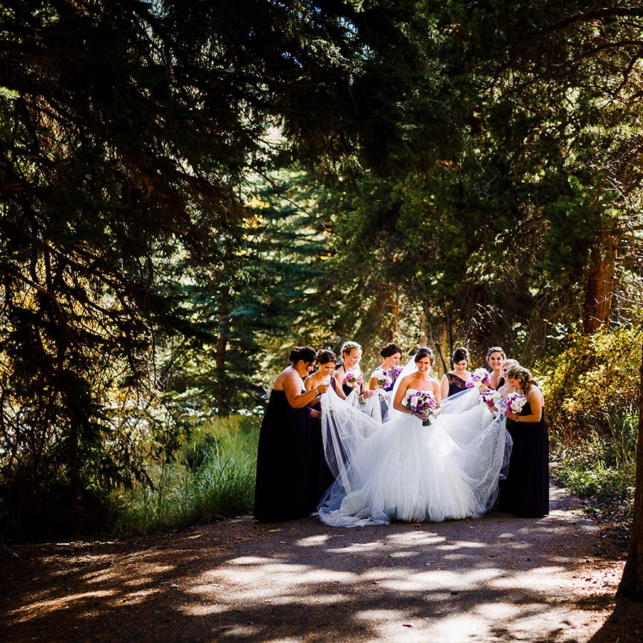 bride getting ready with bridesmaids fixing dress outdoors, autumn wedding in the mountains, destination wedding planner, vail wedding planning, colorado wedding planning, mountain wedding inspiration