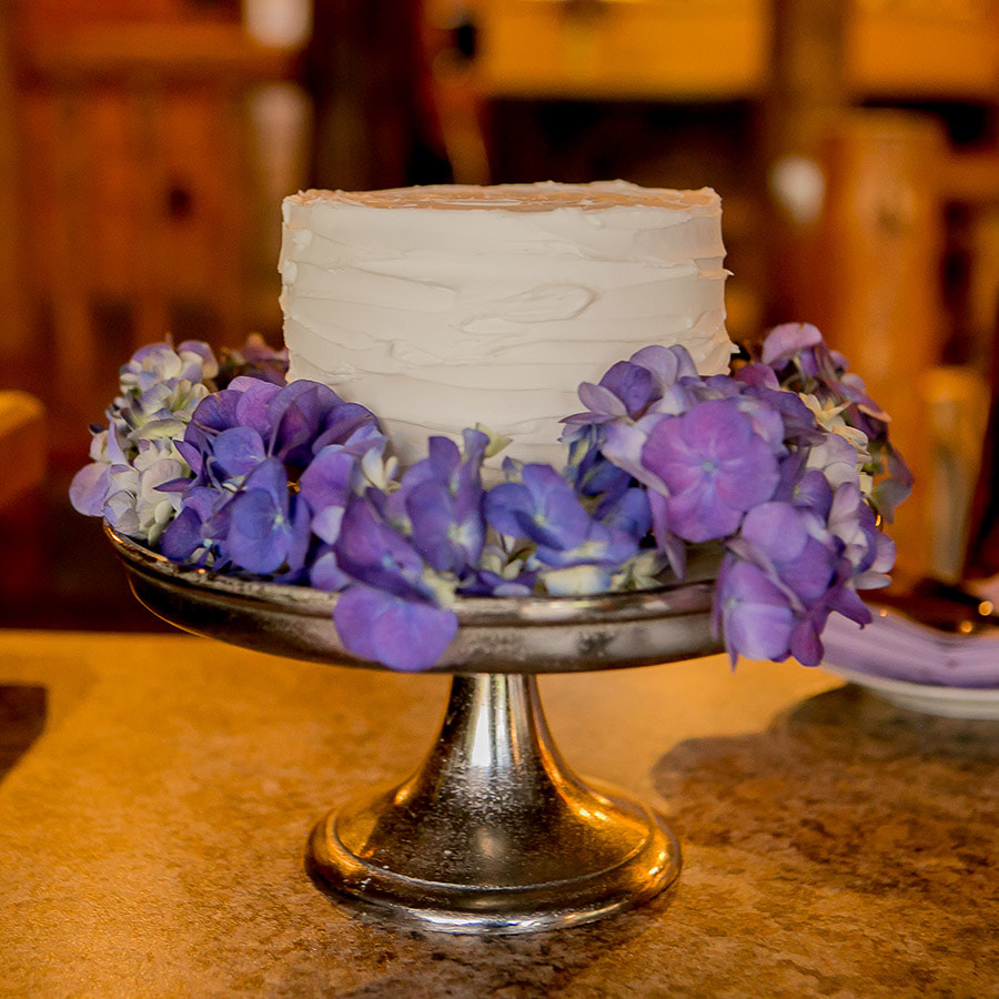cutting cake, blue hydrangeas, silver cake stand, colorado room, intimate spruce mountain ranch wedding, real weddings