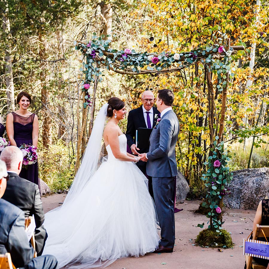 bride and groom holding hands, autumn outdoor ceremony at donovan pavilion, real weddings, colorado wedding inspiration, mountain wedding planners
