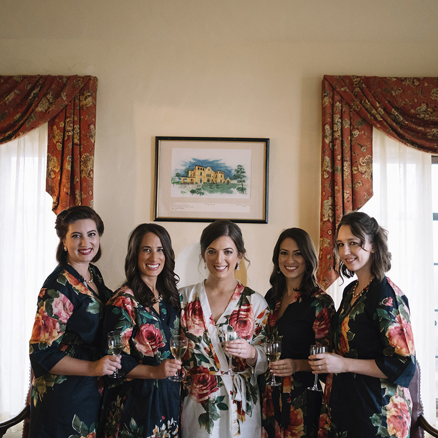 bridal party getting ready photos, bride and bridesmaids in floral robes, drinking champagne in bridal suite, cherokee ranch, mountain wedding planning, colorado wedding inspiration, sweetly paired