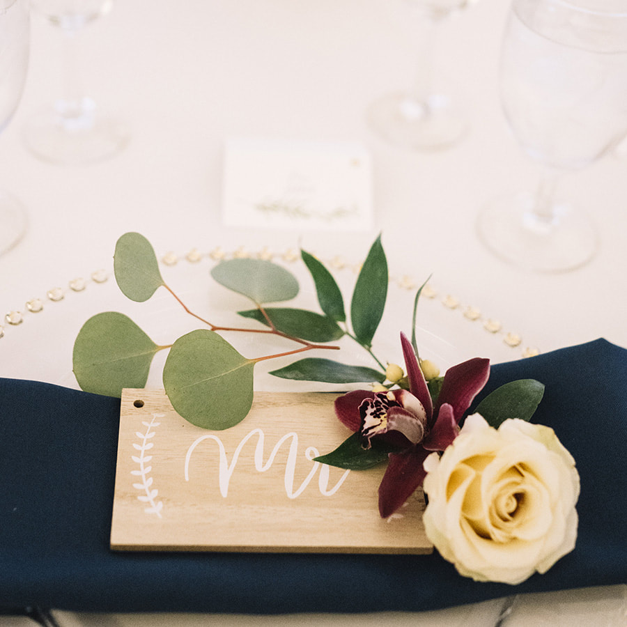 navy and gold wedding colors, table setting with wooden mr sign and floral sprigs, cherokee ranch and castle wedding planner, colorado wedding planning, mountain wedding inspiration