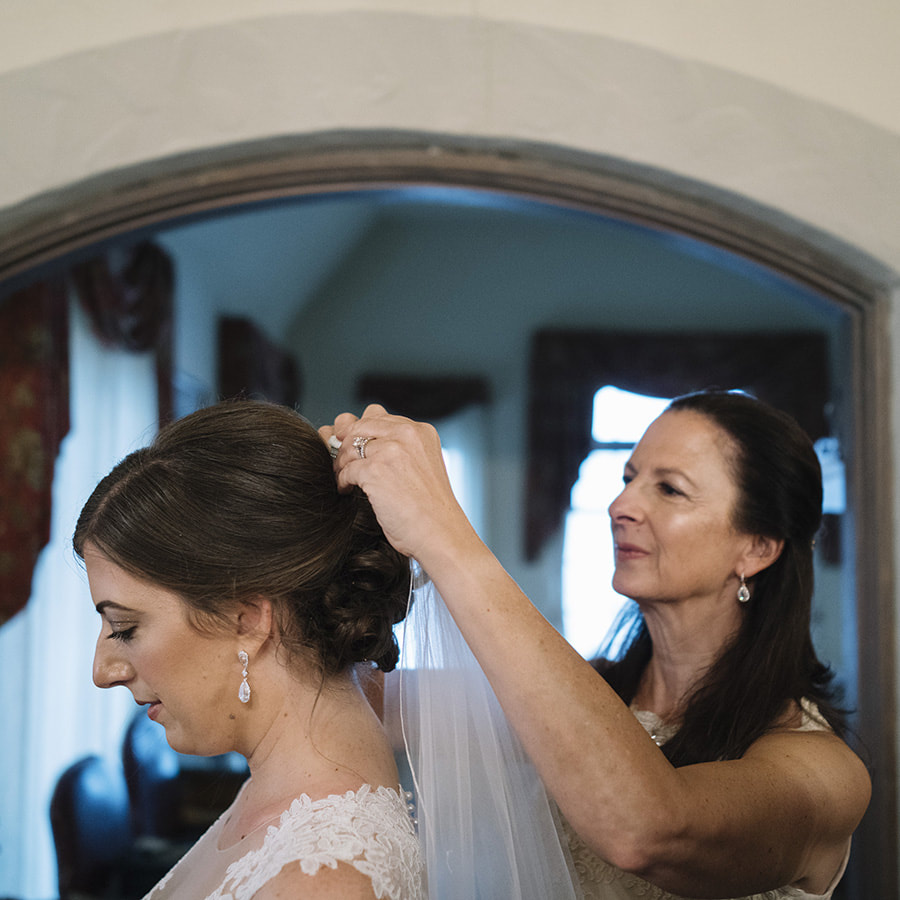 bride getting ready, mom putting veil on bride, bridal suite at cherokee ranch and castle, real weddings, colorado mountain weddings, mountain wedding inspiration, sweetly paired wedding planning