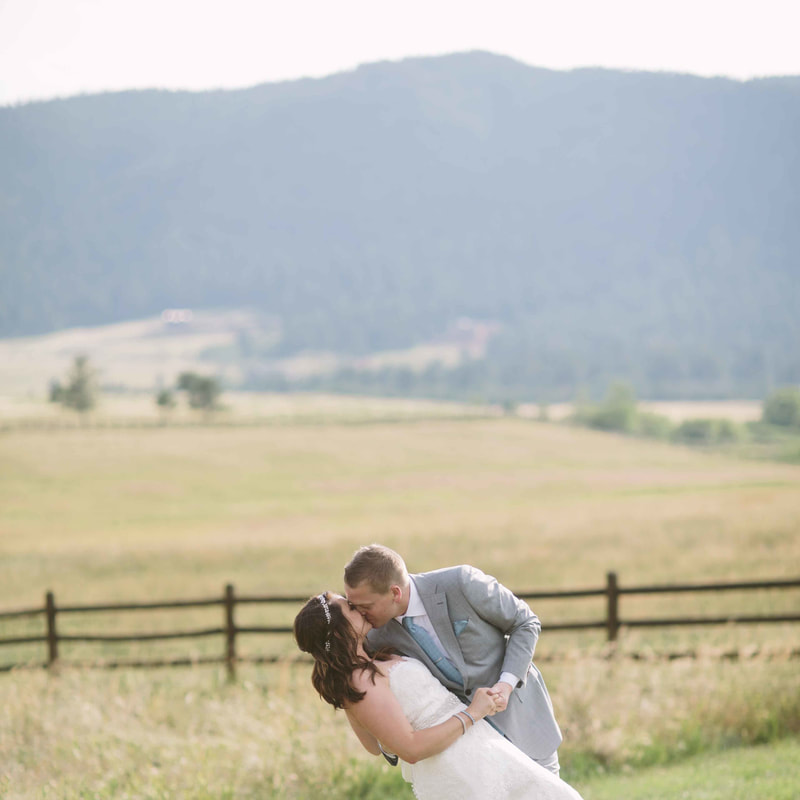 bride and groom portraits, groom dipping bride and kissing in field, spruce mountain ranch weddings, real weddings, mountain wedding planning, colorado wedding inspiration