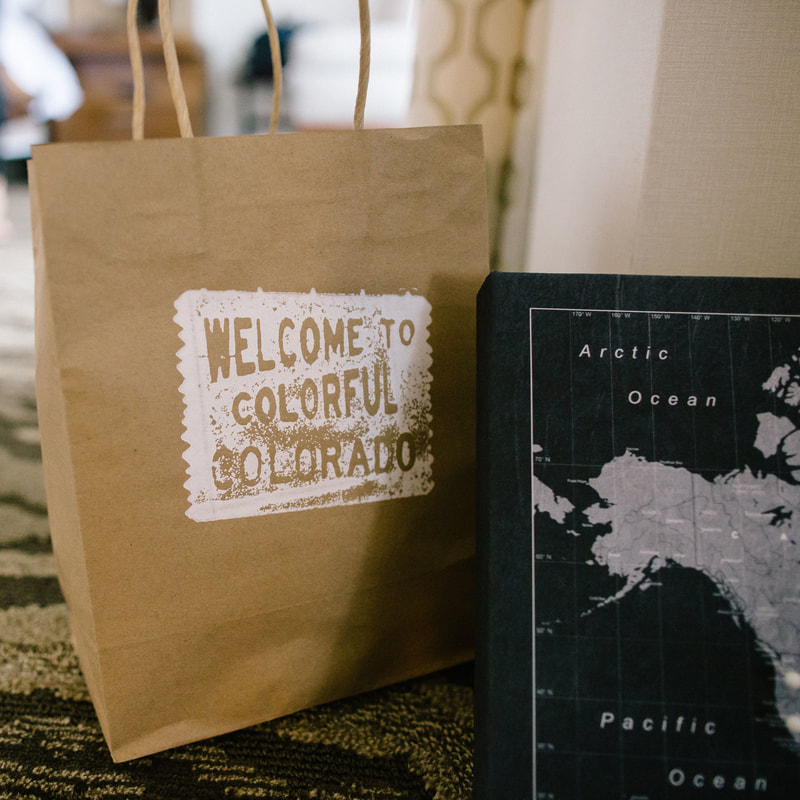 wedding welcome gift bags, welcome to colorful colorado stamp on brown paper bag, map of the world sign, wedding day detail photos, getting ready in hotel room, colorado wedding inspiration, colorado wedding planners